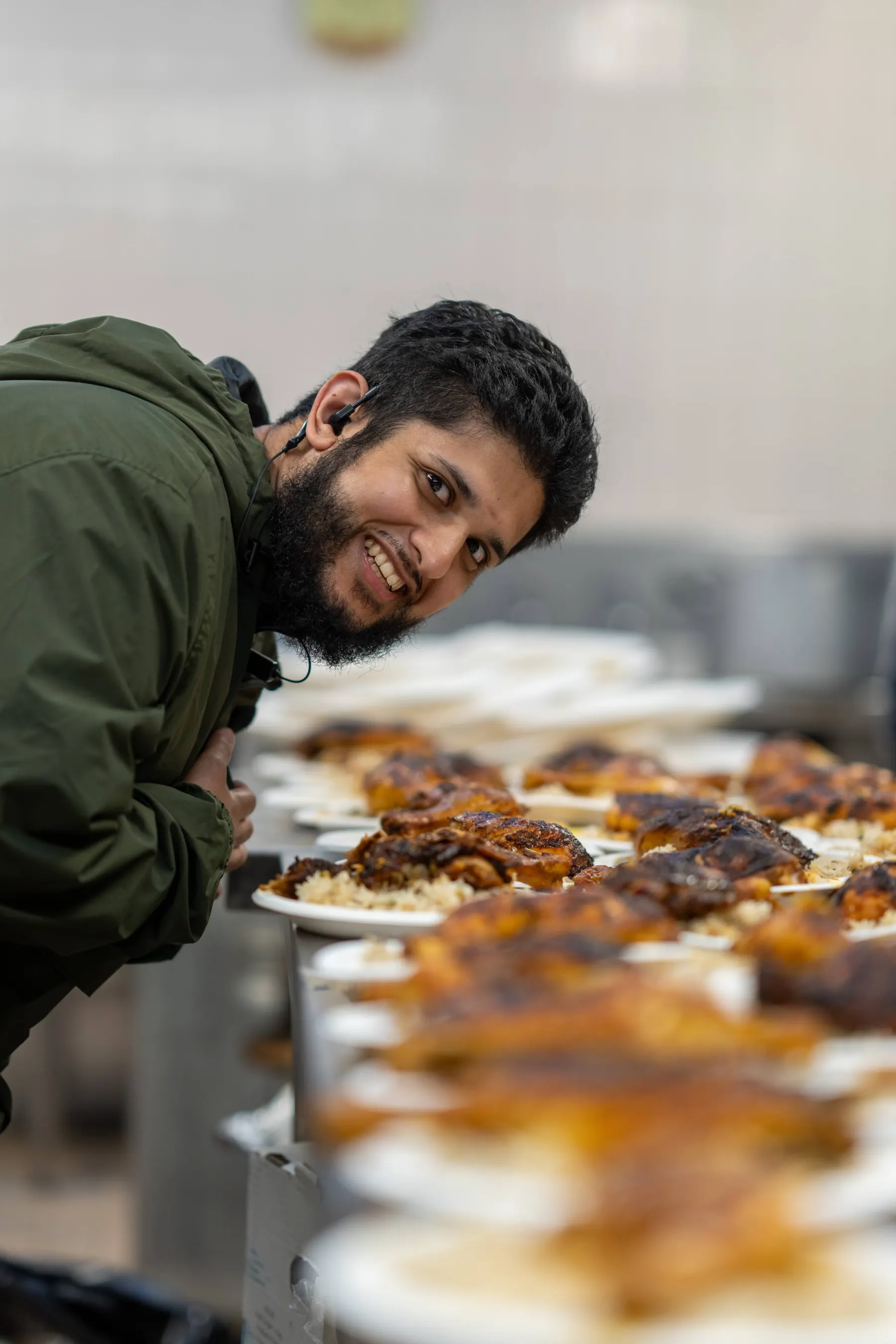 A volunteer smiling while serving a meal at Summer Camp