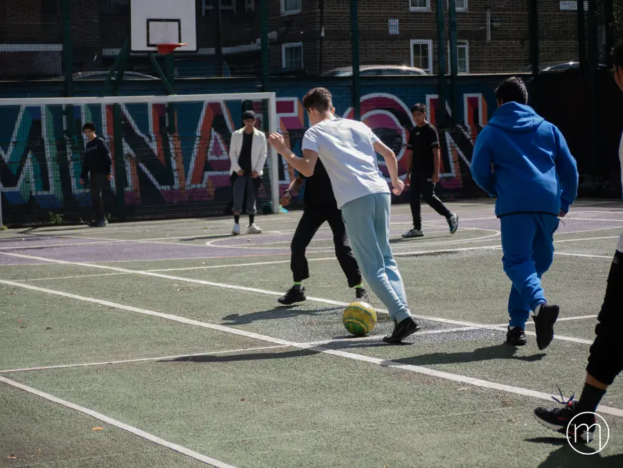 Young people playing football together