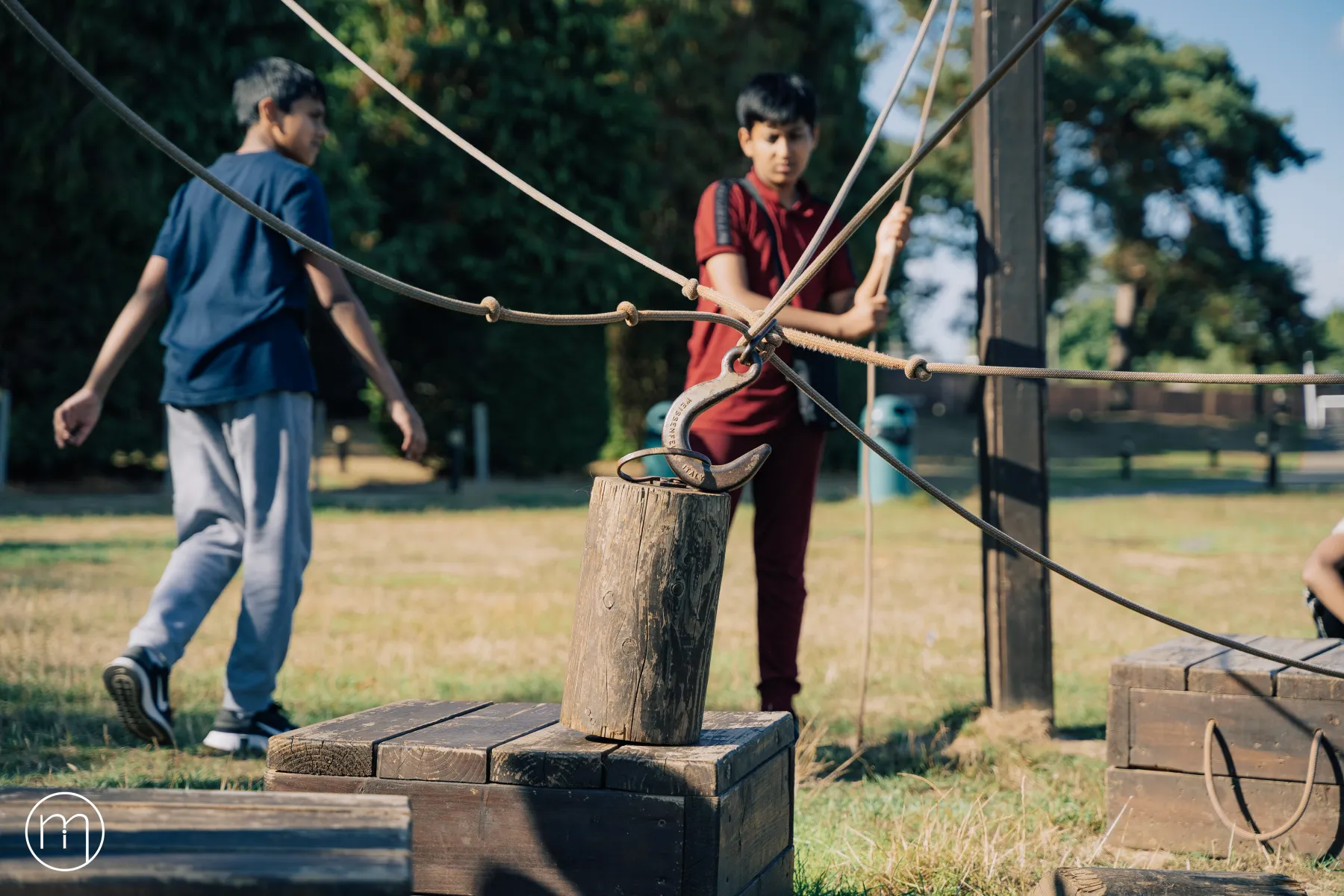 Summer Camp participants navigating a rope-and-post balance obstacle course outdoors