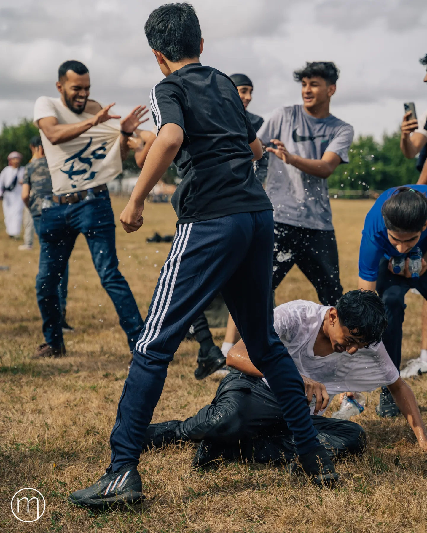 Summer Camp participants enjoying an energetic group game on a grassy field