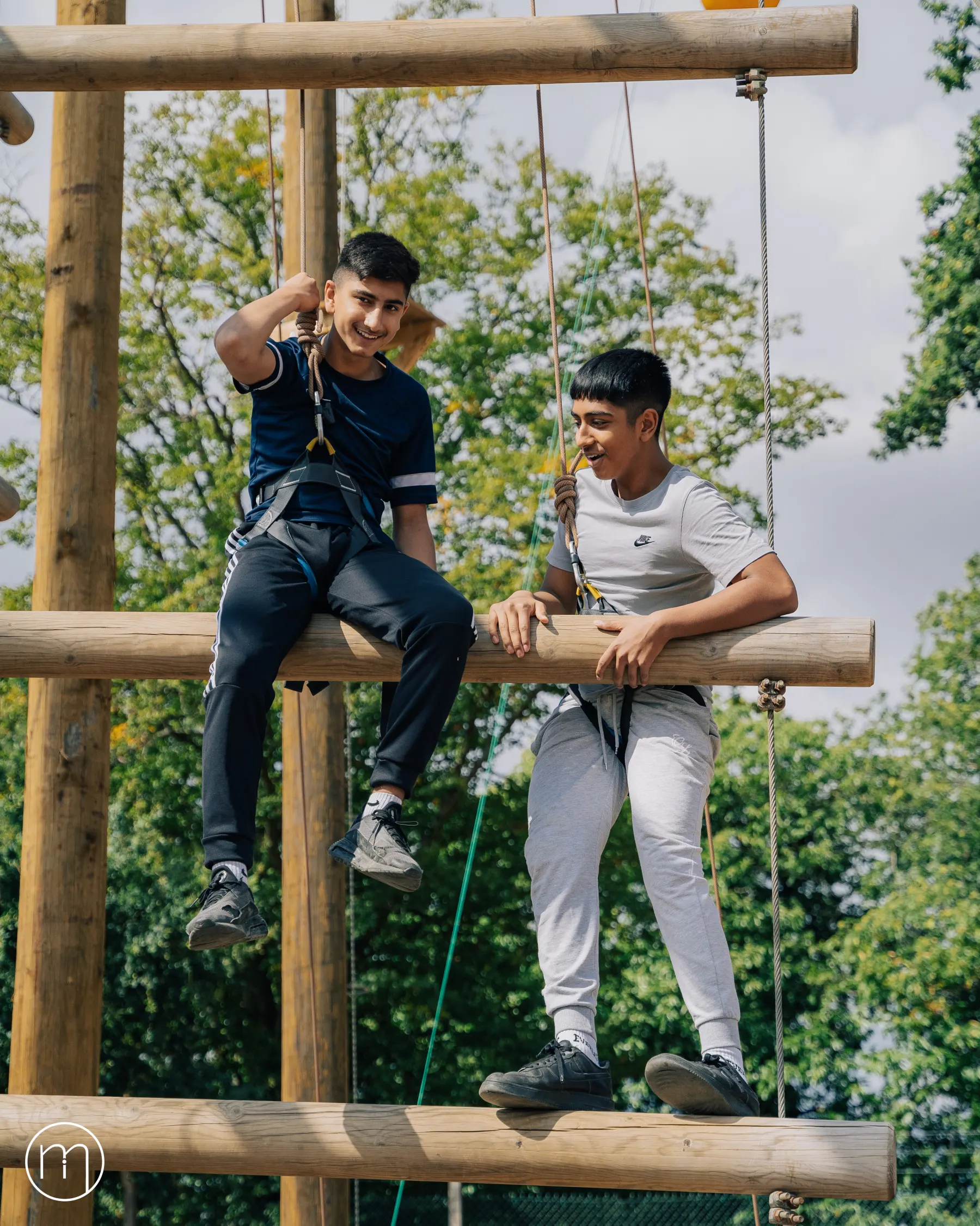 Two participants sitting on a balance beam during an activity